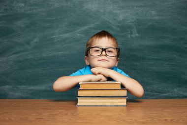 Geri okul kavramı. Sınıfta okul çocuk (Çocuk). Yeşil kara tahta karşı komik çocuk. Fikir ve yaratıcılık kavramı. Kara tahta zemin üzerine boşaltmak