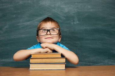 Geri okul kavramı. Sınıfta okul çocuk (Çocuk). Yeşil kara tahta karşı komik çocuk. Fikir ve yaratıcılık kavramı. Kara tahta zemin üzerine boşaltmak