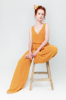 Genç güzel kadın yaratıcı altın makyaj poz çiçekli bir stüdyoda kırmızı saçlı