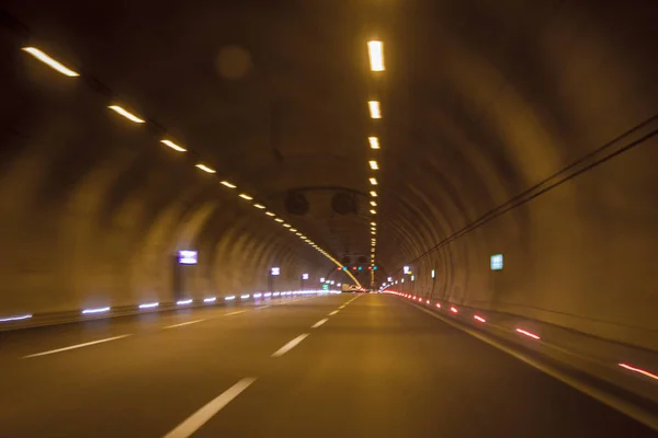 Motorway highway tunnel interior view,yellow light lighting, blurred vision