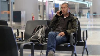 Genç adam terminal konuşmak Havaalanı yolcu uçak beklerken telefon ile