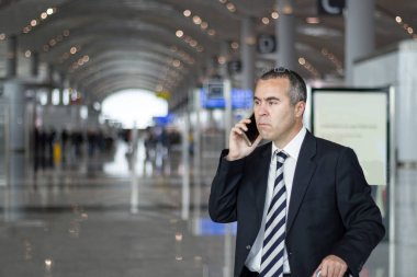 İş adamı havaalanında konuşmak telefon ile