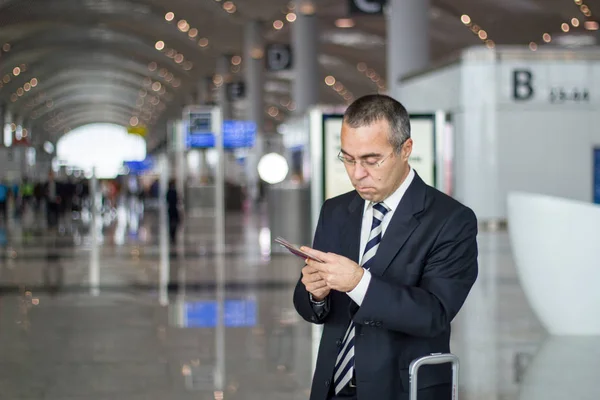 Business man at the airport checking passport and ticket