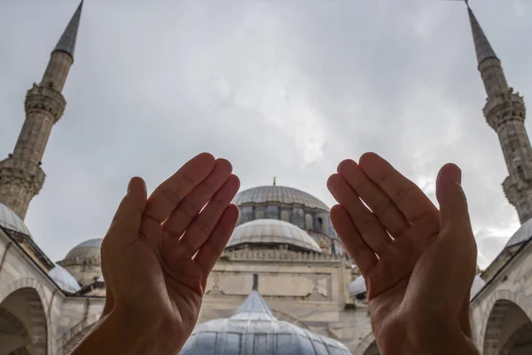 Muslim praying hands, mosque and minaret background