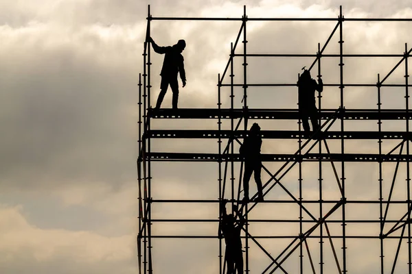 İnşaat İşçileri siluet demir platformu gökyüzü arka plan üzerinde çalışma