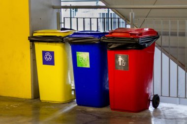 Sarı, mavi, kırmızı çöp kutusu ve geri dönüşüm sembolü