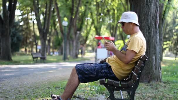 Man Hatt Och Solglasögon Använder Smartphone Park Bänken Man Använder — Stockvideo