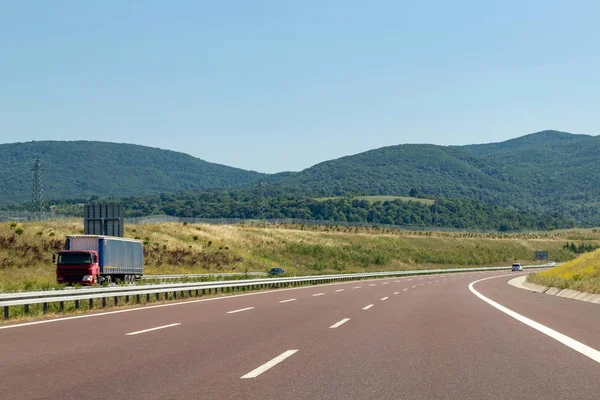 Şehir kırsalının dışında çok şeritli otoyol. Viraj yolu. Yaz güneşli gün