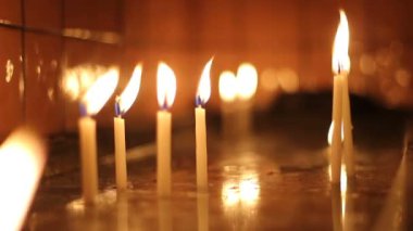 Kilisedeki suda yanan dua mumları.