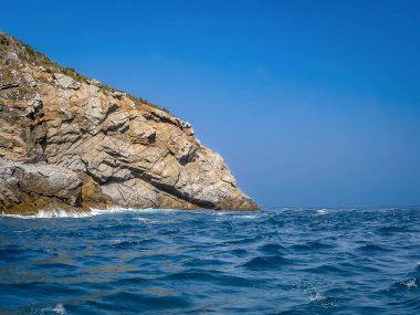 Denizden bir güneşli gün ve sakin deniz, gökyüzü ve deniz gördüm Cabo Frio ada kenarında güzel deniz manzarası mavi ve sahil cliff denize aslope