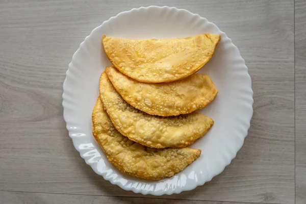 Un ramo de cuatro pastas fritas brasileñas sobre un plato blanco — Foto de Stock