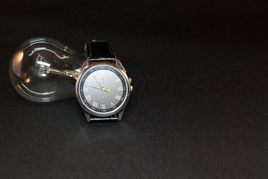 Elektrik lambası ve saati, zamanın sembolü.