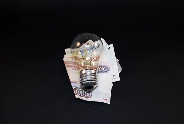 Electric and energy saving light bulb and money, economy concept.