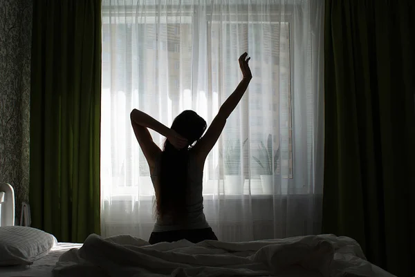 창가에 침대에 머리를 여자의 실루엣 — 스톡 사진