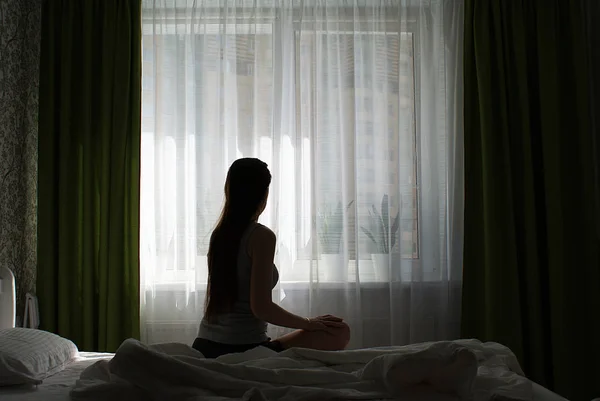 Silhouette Una Ragazza Con Capelli Lunghi Sul Letto Vicino Alla — Foto Stock