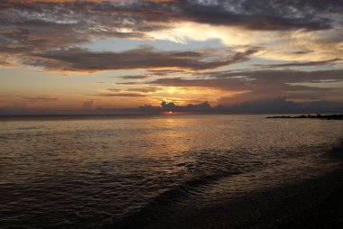 Denizde gün batımı, güzel bulutlar, arka plan.