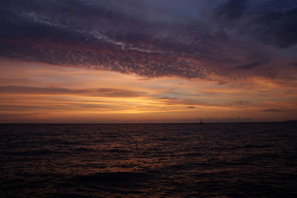 Denizde gün batımı, güzel bulutlar, arka plan.