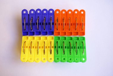 Açık bir arka plan üzerinde renkli giysiler mandal.