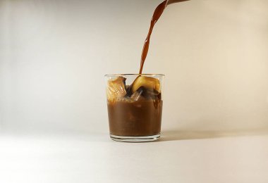 Bir bardak, buz küpleri süt ile soğuk kahve dökün.