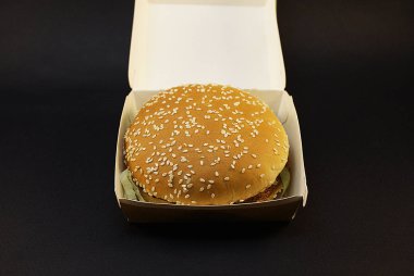 Zararlı burger, koyu bir arka plan üzerinde fast food.