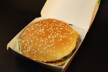 Zararlı burger, koyu bir arka plan üzerinde fast food.