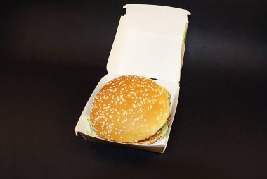 Zararlı burger, koyu bir arka plan üzerinde fast food.