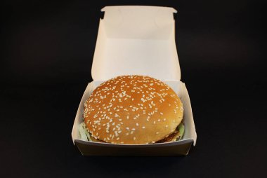 Zararlı burger, koyu bir arka plan üzerinde fast food.