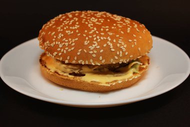 Zararlı burger, koyu bir arka plan üzerinde fast food.