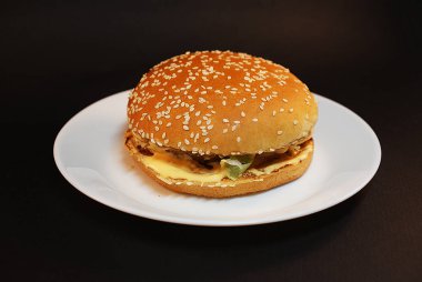 Zararlı burger, koyu bir arka plan üzerinde fast food.