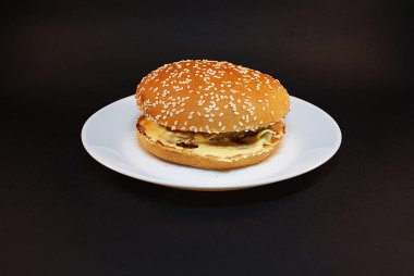 Zararlı burger, koyu bir arka plan üzerinde fast food.