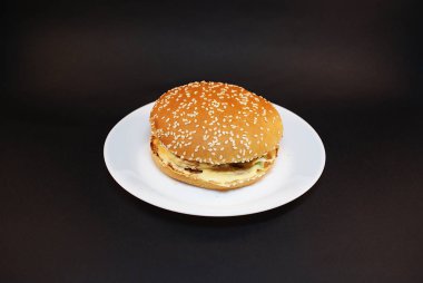 Zararlı burger, koyu bir arka plan üzerinde fast food.