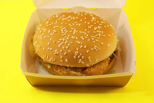 Zararlı burger, sarı arka planda fast food.