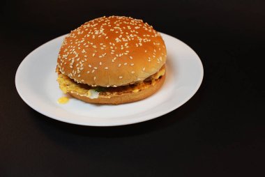 Zararlı burger, koyu bir arka plan üzerinde fast food.