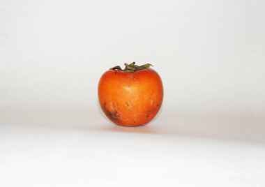 Beyaz arka planda izole edilmiş olgun portakal hurması..