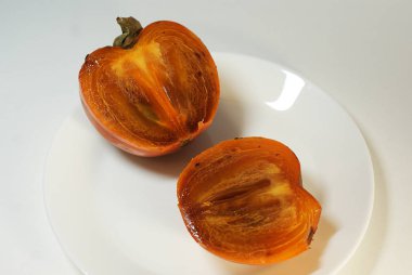 Beyaz arka planda izole edilmiş olgun portakal hurması..