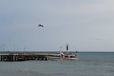 Deniz kıyısındaki rıhtımın yanında yat.