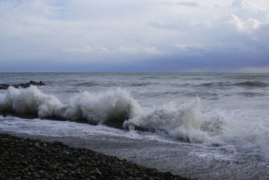 Fırtına, güçlü dalgalar, deniz kıyıları, kumsalda çakıl taşları.