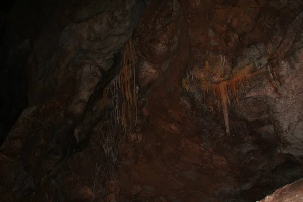 A cave with stalactites and stalagmites in an underground cave, rocks.
