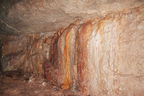 A cave with stalactites and stalagmites in an underground cave, rocks.