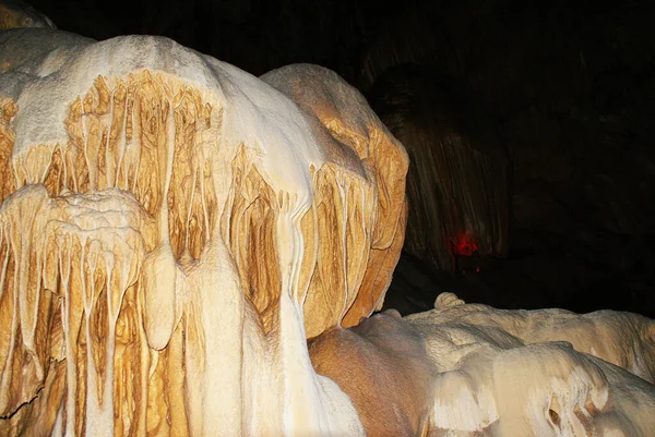 A cave with stalactites and stalagmites in an underground cave, rocks.