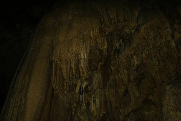 A cave with stalactites and stalagmites in an underground cave, rocks.