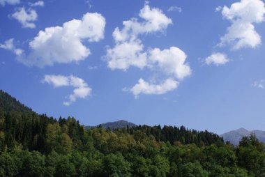 Berrak gökyüzü, bulutlar ve manzara ile güzel bir sıradağ..