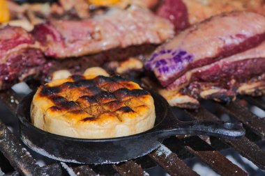 Lezzetli Arjantin Provolone İplik Peyniri (Provoleta) bir barbekü ızgara üzerinde dökme demir tavada pişirilir, Buenos Aires, Arjantin eyaleti. Yakın çekim sahnesi. Barbekü arka plan. 
