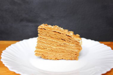 Siyah arka plan üzerine beyaz tabakta bal pastasından