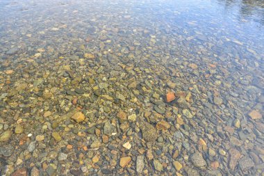 Arka plan - nehir çakıl. Nehir su ince bir tabaka altında.