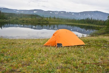 Gölet yakınındaki'nın bahçesinde çadır. Bulutlu göl manzaralı, Putorana Yaylası, Taimyr, Rusya Federasyonu.