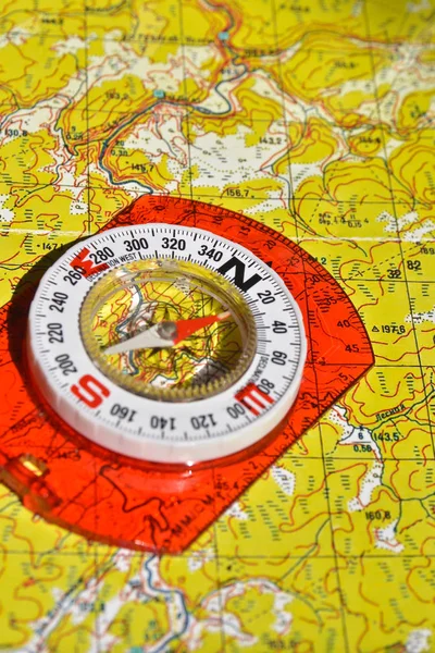 The compass lies on the map. Navigation tools needed for orientation.