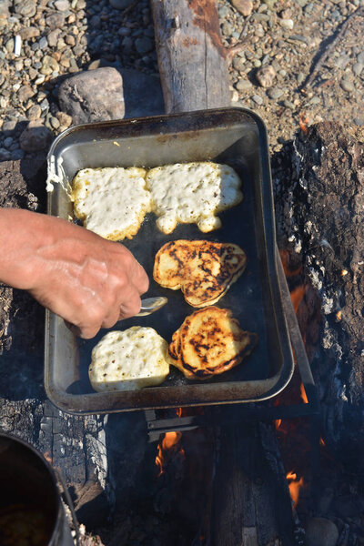 Crispy fritters on the baking sheet. Baking scones in the camp.