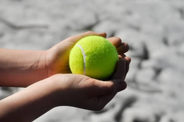 Palla Tennis Gialla Illuminata Dal Sole Giace Nelle Mani Bambino — Foto Stock
