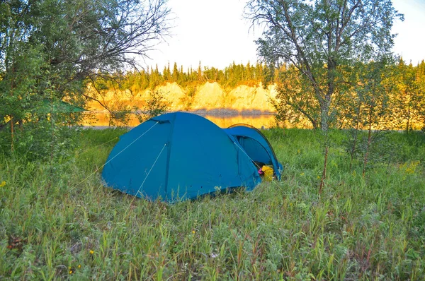 Camping tent on the bank of a river.